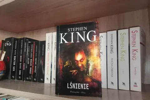 Półka z książkami Stephena Kinga, w tym "Lśnienie", "Cmętarz zwierząt" i "Nocna zmiana".