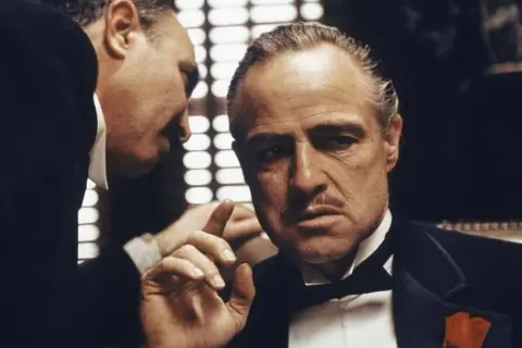 Don Vito Corleone, ojciec chrzestny, słucha rady.