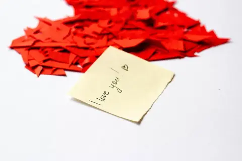 Kawałki czerwonego serca i karteczka z napisem "I love you!". To dowód, że kocham Cię w każdym języku.