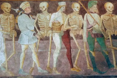 Szkielety i ludzie w średniowiecznych strojach tworzą procesję. To jedne z wielu przykładów danse macabre, ukazujące nieuchronność śmierci.